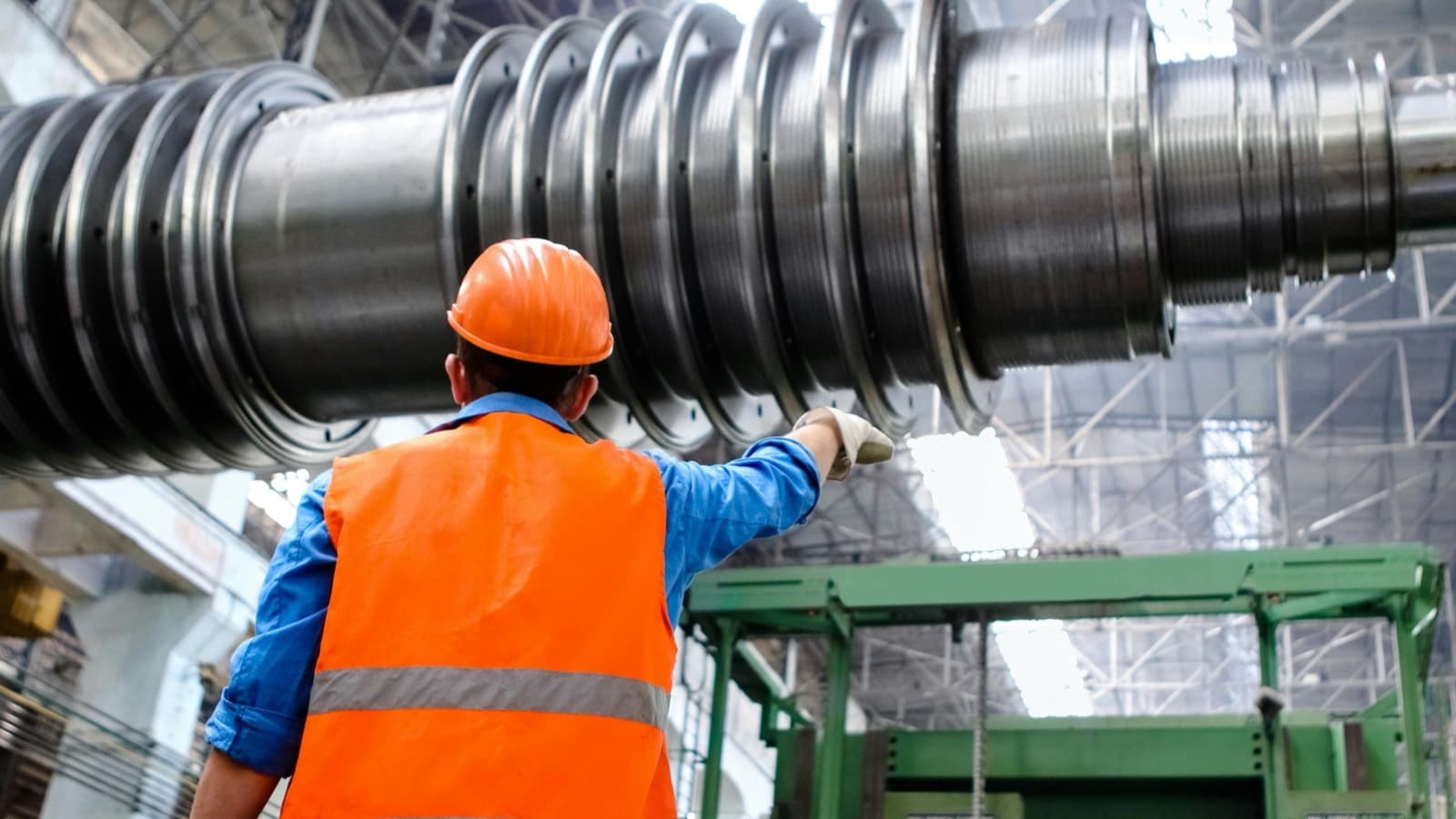 Engineer in high-visibility gear inspecting heavy machinery during a vendor audit
